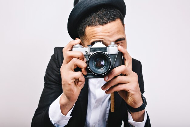 근접 촬영 초상화 세련 된 남자 모자, 정장 카메라에 사진 만들기. 행복한 관광, 재미, 기쁨, 절연, 미소, 양성, 쾌활한 분위기, 사진 작가 표현.