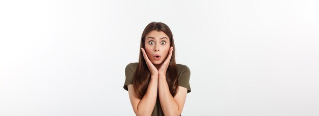 Closeup portrait of surprised beautiful girl holding her head in amazement and openmouthed over whit