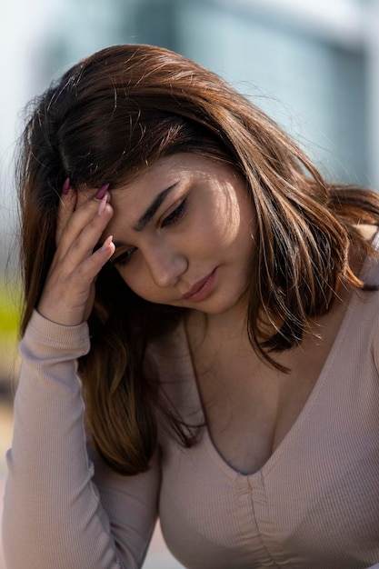 Free photo closeup portrait of upset girl sitting at the street and looking down high quality photo