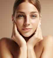 Free photo closeup portrait of a woman looking stright at camera and touching her face