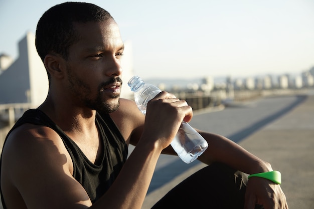 Closeup portrait of young bearded man drinking water