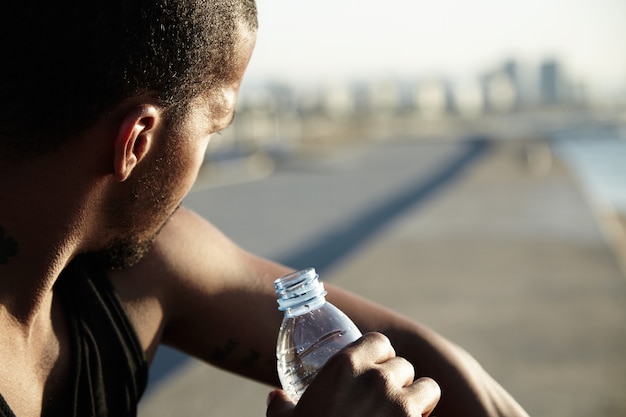 Closeup portrait of young bearded man drinking water