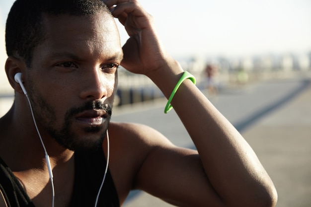 Closeup portrait of young bearded man listening to music