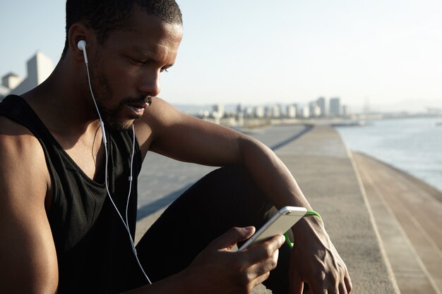 音楽を聴いている若いひげを生やした男のクローズアップの肖像画