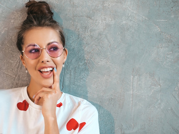 Closeup portrait of young beautiful smiling woman looking . trendy girl in casual summer white dress and sunglasses. . thinking