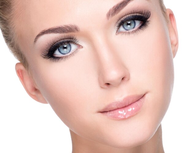 Free photo closeup portrait of young beautiful white woman with long false eyelashes  over white wall