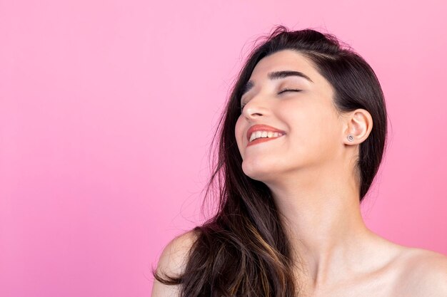 Closeup portrait of young lady smiling on pink background High quality photo