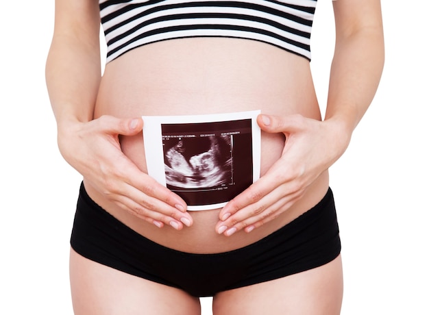 Closeup pregnant woman holding ultrasound image