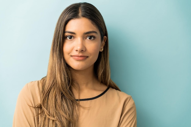 Closeup of pretty young woman with long hair standing against isolated background