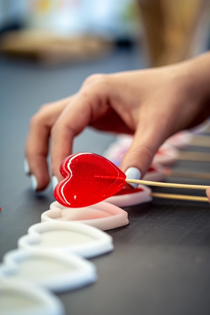 Primo piano il processo di creazione di lecca-lecca a forma di cuore