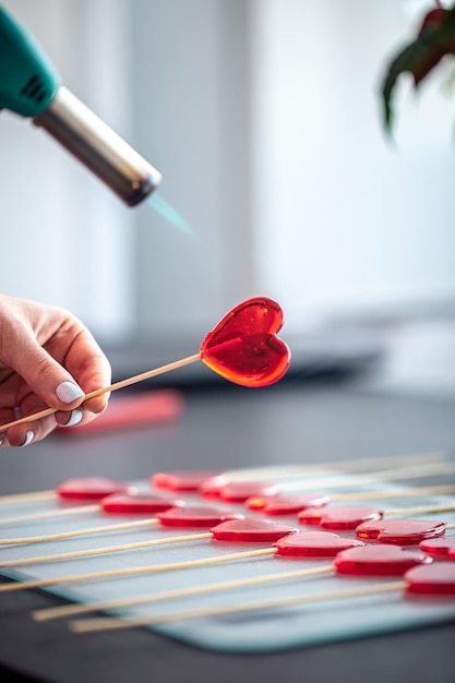 Primo piano il processo di creazione di lecca-lecca a forma di cuore