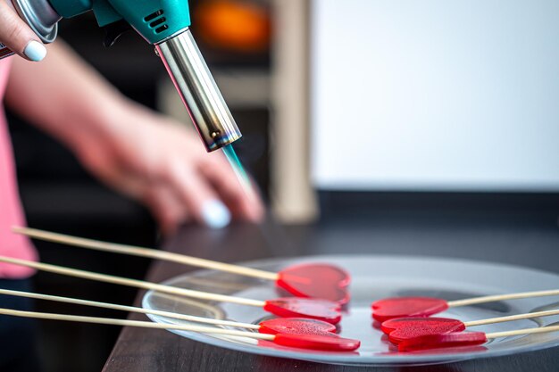 Closeup the process of making heartshaped lollipops