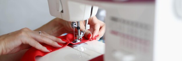 Closeup of professional female tailor using sewing machine for work interesting process of