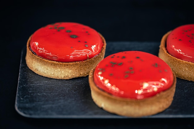 Closeup of red pastry tarts on a black background