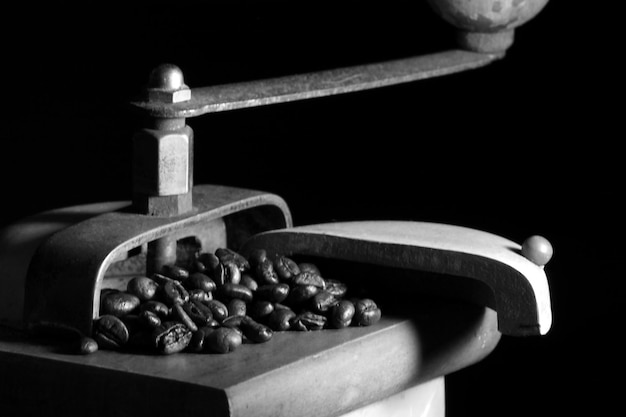 Closeup of roasted coffee beans in an old coffee grinder against a black backgrou