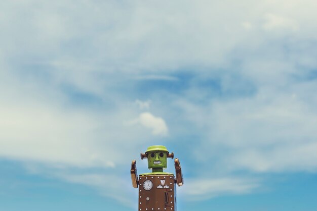 曇った青空の景色とロボットのおもちゃの拡大