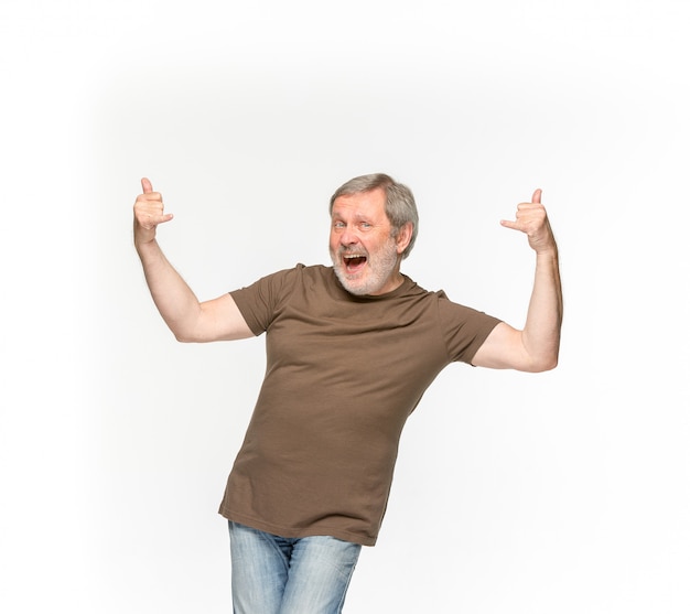 Closeup of senior man's body in empty brown t-shirt isolated on white background. 