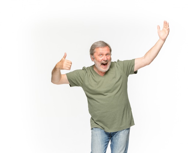 Free photo closeup of senior man's body in empty green t-shirt isolated on white space. mock up for disign concept