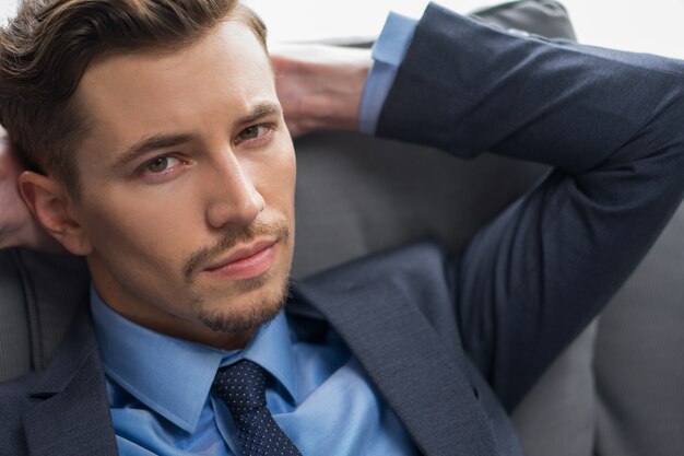 Closeup of Serious Businessman Resting on Cushion