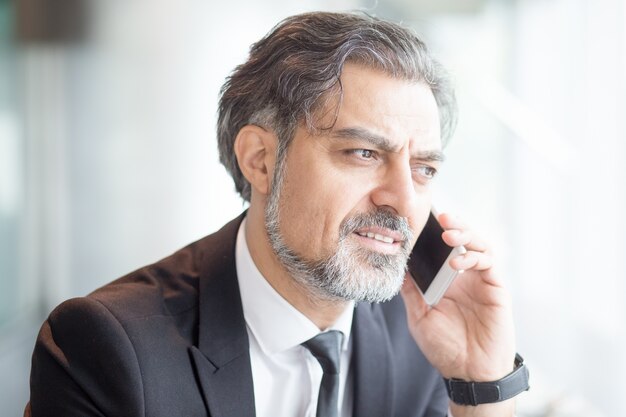 Closeup of Serious Entrepreneur Calling on Phone