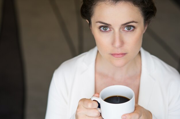 Крупным планом серьезного Nice деловая женщина с кофе
