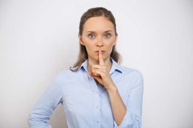 Free photo closeup of serious woman making silence gesture