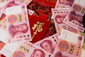 Free photo closeup shot of 100 chinese yuan (cny) banknotes and chinese traditional red envelop