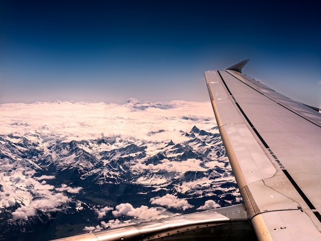 Closeup shot of an airplane wing and mountains