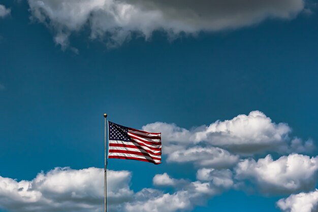 Closeup shot of the American flag waving in the air under a cloudy sky