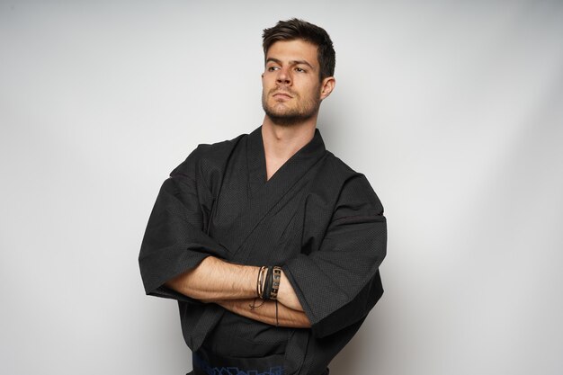 Closeup shot of an attractive male standing with crossed arms isolated over white background