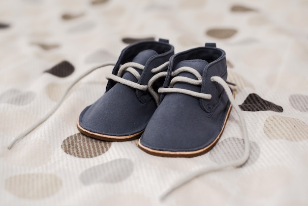 Closeup shot of baby boy shoes on a bed
