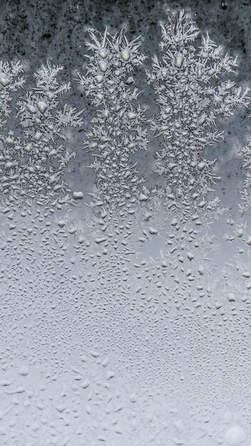 Closeup shot of beautiful frost snowflakes texture on a glass
