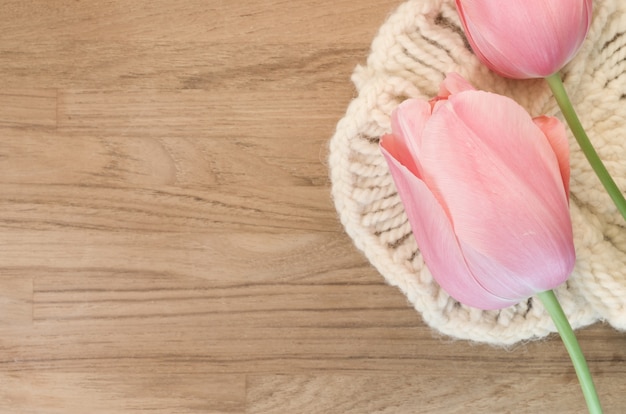 Closeup shot of beautiful pink tulips on wooden background