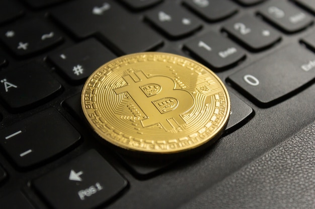 Closeup shot of a bitcoin put on a black computer keyboard