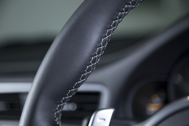 Closeup shot of a black car's modern interior wheel