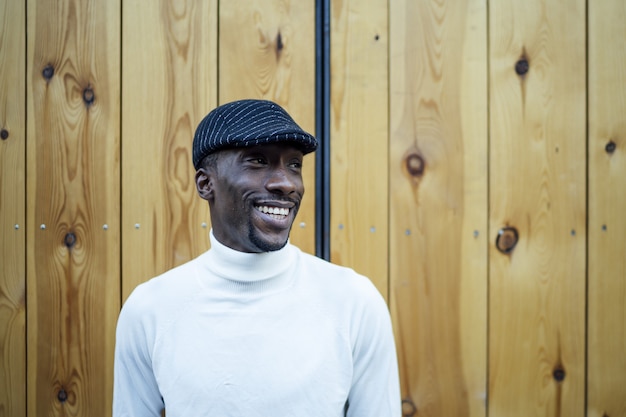 Closeup shot of a black man wearing a hat and a turtleneck