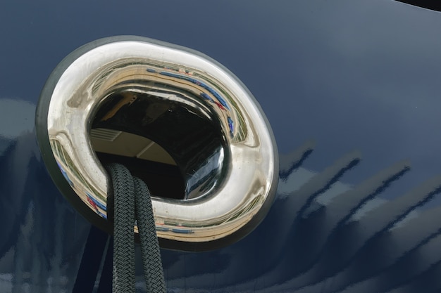 Closeup shot of black mooring rope through a round yacht window