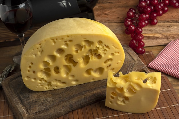 Primo piano di un blocco di formaggio svizzero gourmet su una tavola di legno