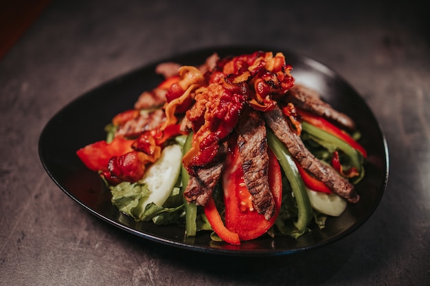 Closeup shot of a bowl of delicious meat dish on a wooden table