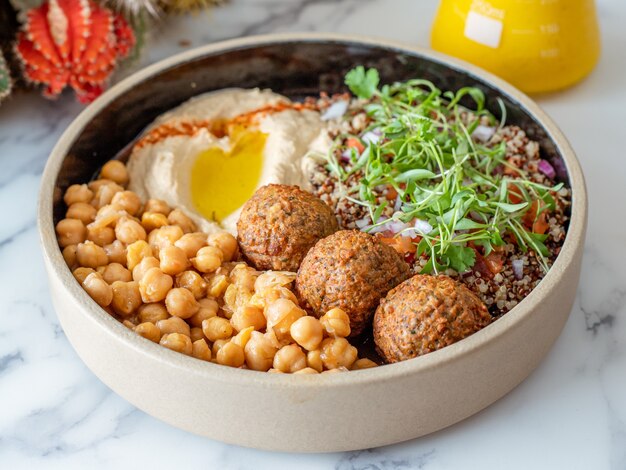 Closeup shot of a bowl of meatballs with chickpeas, grain, and egg