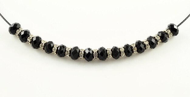 Closeup shot of a bracelet with black shiny beads isolated on a white background in studio