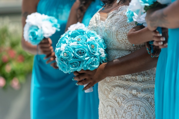 Closeup shot of the bride and her bridesmaids standing and holding bouquets, no faces captured