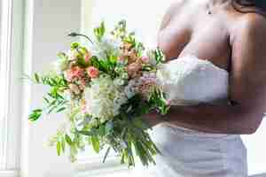 Free photo closeup shot of a bride in a white dress holding a flower bouquet