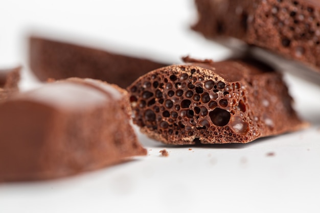 Closeup shot of bubble chocolate pieces isolated on a white surface