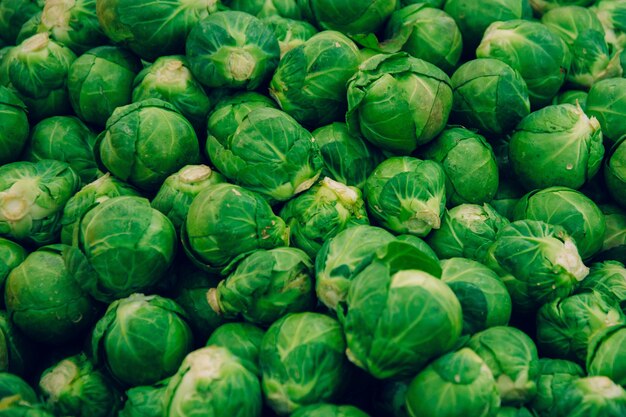 Closeup shot of cabbages on each other under the lights at a market