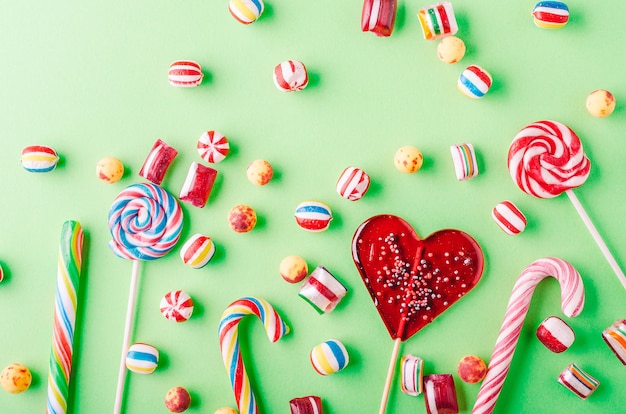 Free photo closeup shot of candy canes and other candies on a green background