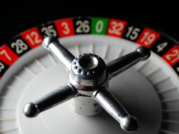 Closeup shot of a casino roulette wheel on a black surface