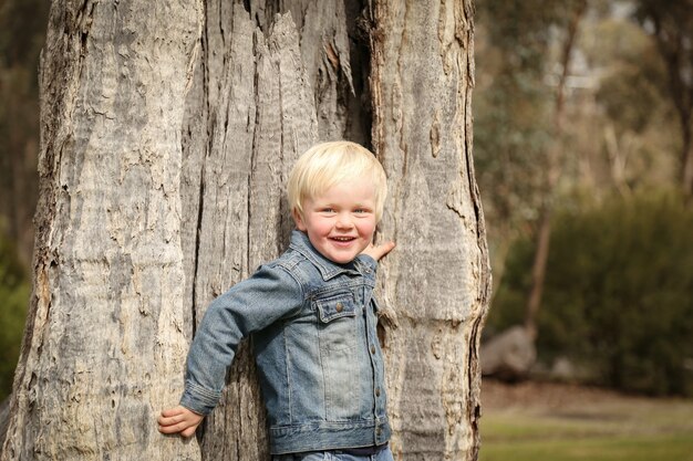 Closeup shot of a Caucasian blond boy playing in a park