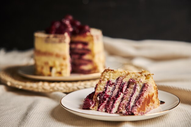 白いプレート上の桜のケーキのスライスのクローズアップショット