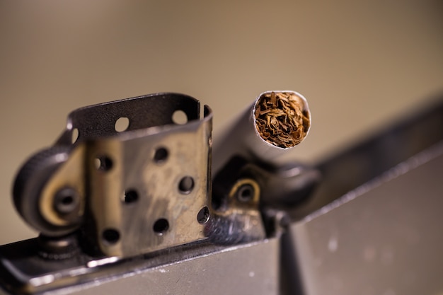 Closeup shot of a cigarette in a zippo lighter